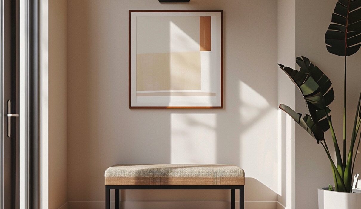 Minimalistyczny przedpokój z tapicerowaną ławką i abstrakcyjnym obrazem